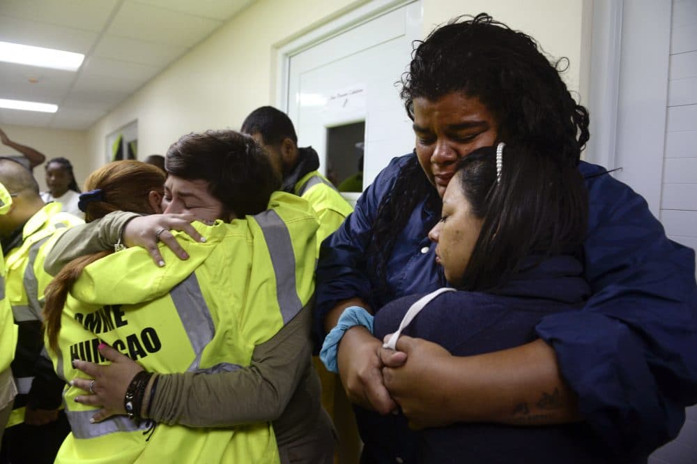 Rescue team members Candida Lozada, left, and Stephanie Rivera, second from left, Mary Rodriguez, second from right, and Zuly Ruiz, right, embrace as they wait to assist in the aftermath of the hurricane in Humacao, Puerto Rico on Wednesday. (Carlos Giusti/AP)