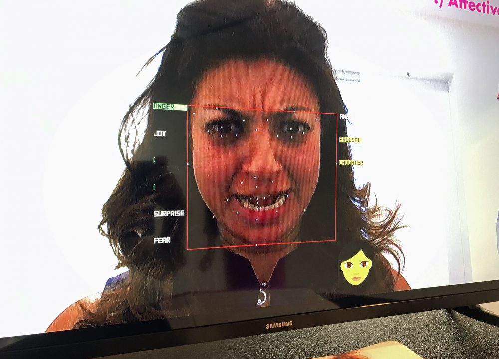 Rana el Kaliouby tests out her company's 'emotion AI' technology. The data points on the left offer analysis of her facial expressions, while the data points on the right refer to her voice and tone. (Asma Khalid/WBUR) 