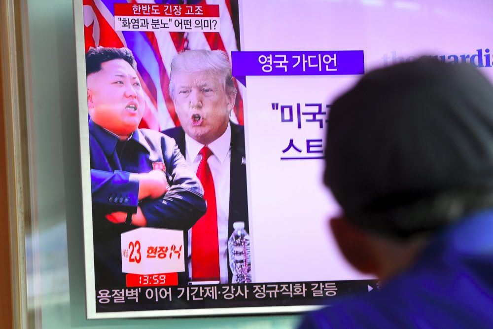 A man watches a television news program showing President Trump and North Korean leader Kim Jong Un at a railway station in Seoul on Aug. 9, 2017. (Jung Yeon-Je/AFP/Getty Images)