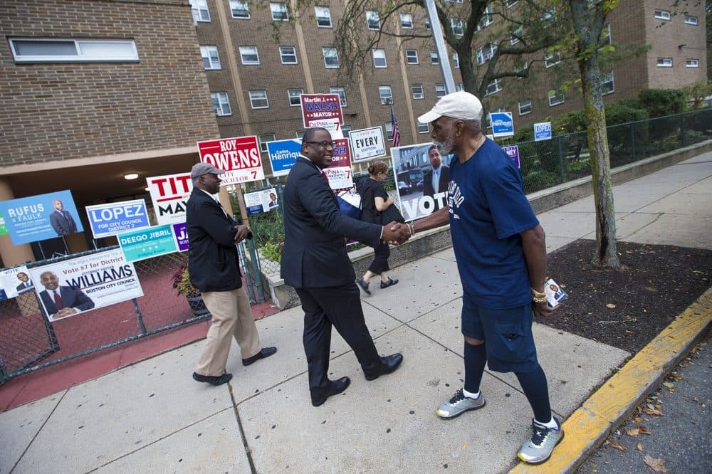 Boston mayoral candidate Tito Jackson shakes hands with a supporter outside of the Holgate Apartments in Dorchester. (Jesse Costa/WBUR)