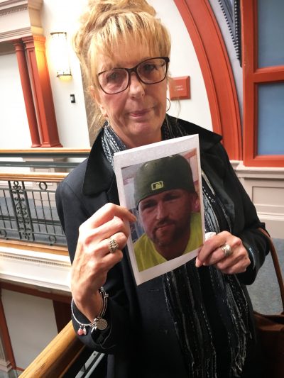 Diana McEvoy holds a photo of her son Joshua Miller, who died of a drug overdose. (Deborah Becker/WBUR)