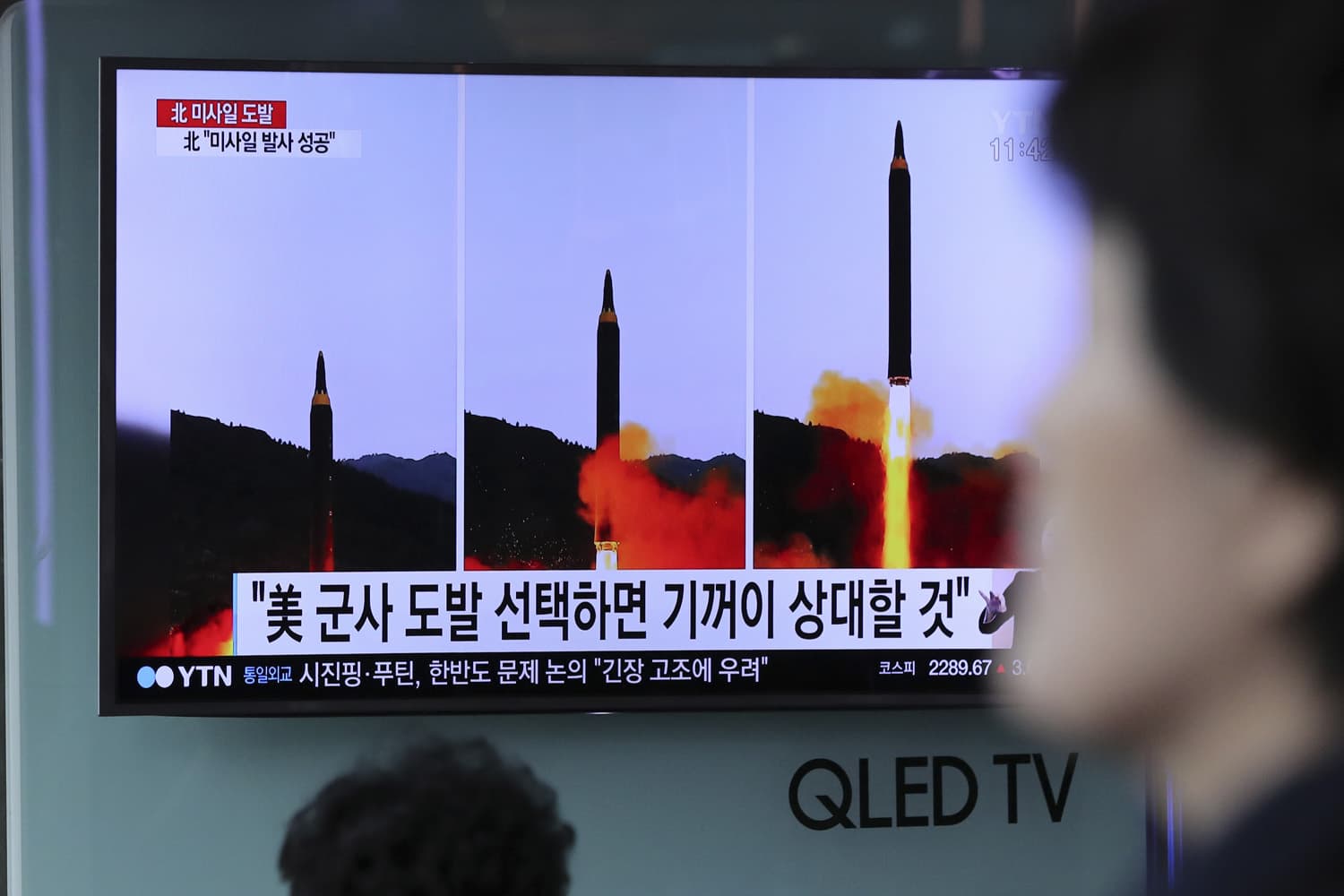 A woman walks by a TV news program showing images of North Korean missile launch, published in the country's Rodong Sinmun newspaper, at Seoul Railway station in Seoul, South Korea, Monday, May 15, 2017. (Lee Jin-man/AP)