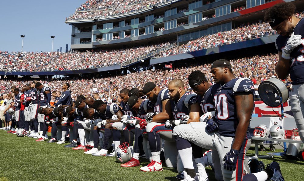 Patriots players kneel during the national anthem before Sunday's game. (Michael Dwyer/AP)