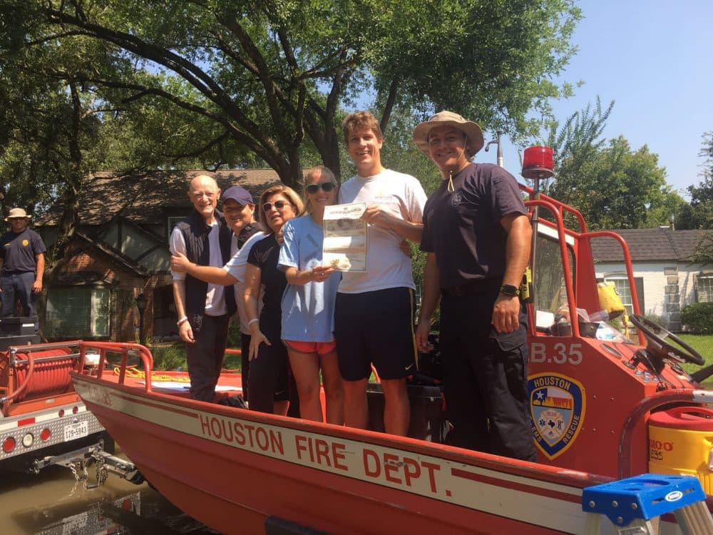 Carla Fallick (fourth from left) and Zack Wilson (second from right) aboard a Houston Fire Department boat in front of their house. They were married in a ceremony conducted by Carla's brother, amidst the flood waters. 