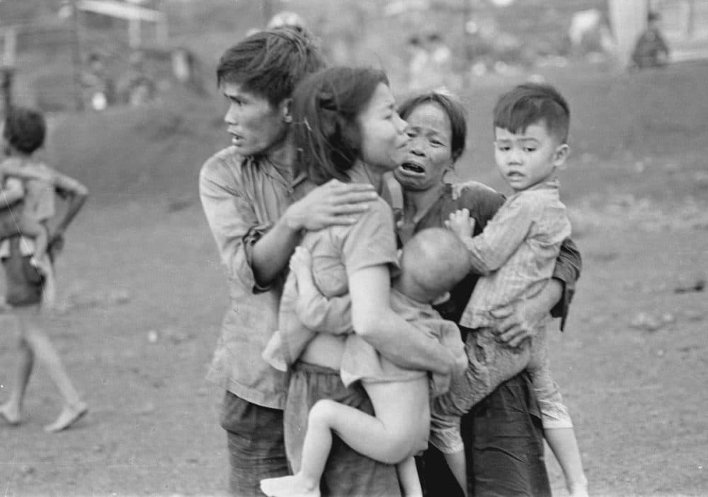 Civilians huddle together after an attack by South Vietnamese forces in Dong Xoai around June 1965. (Horst Faas/AP)