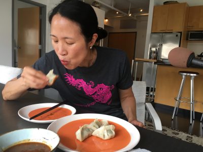 Joanne Chang enjoys the pork and chive dumplings (Meghna Chakrabarti/WBUR)