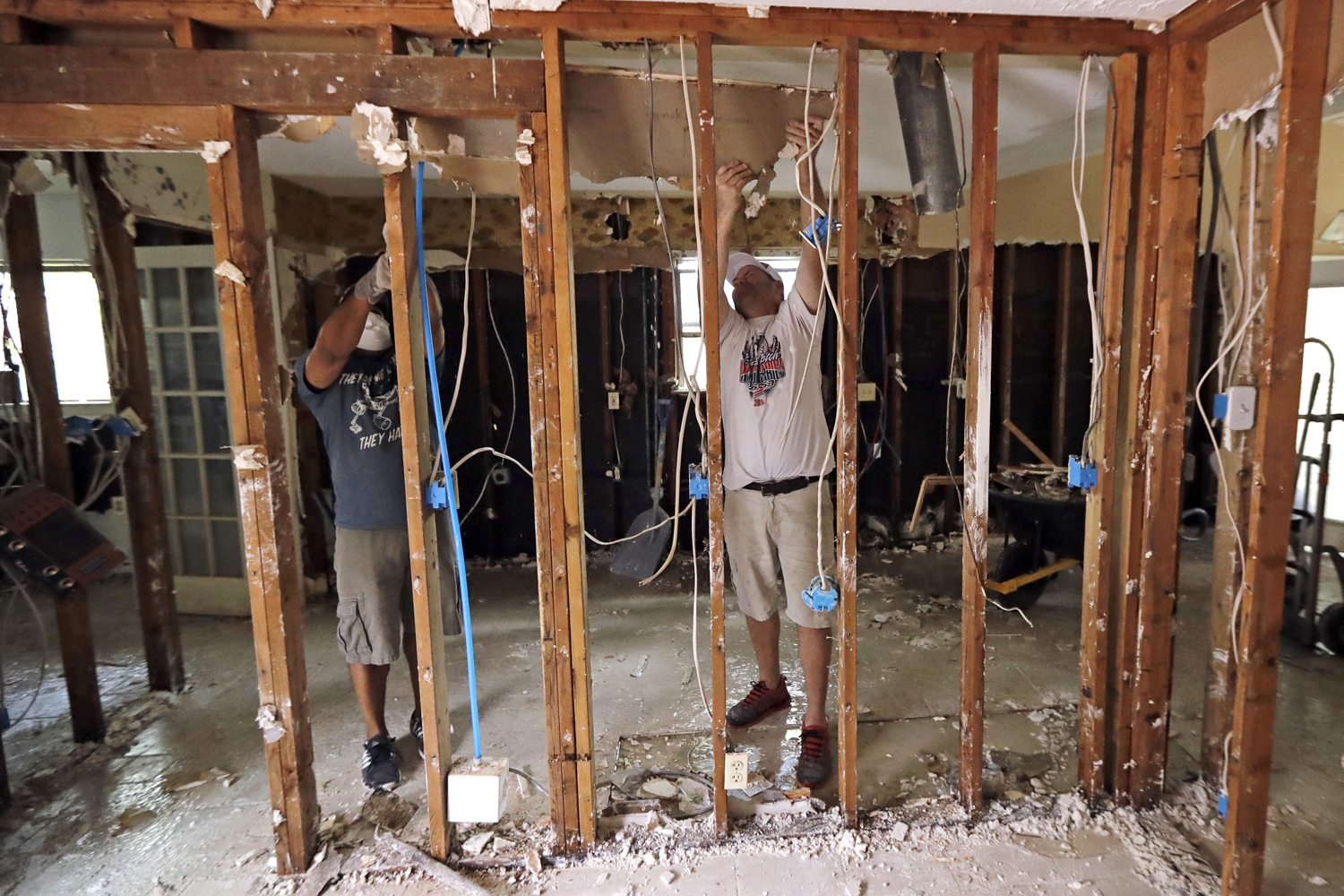 Volunteers Jason Luck, right, and Ryan Colaco remove drywall from a home destroyed by floodwaters in the aftermath of Hurricane Harvey in Spring, Texas. (David J. Phillip/AP)