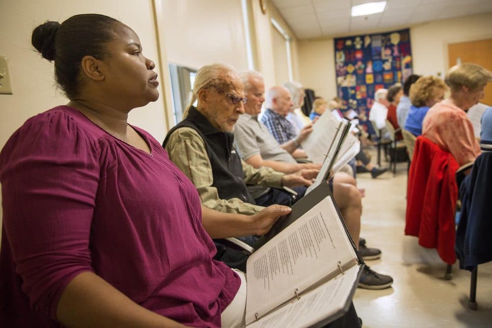 Jean Louis sits beside Neuberg as the two attend a chorus session at the Brookline Senior Center. (Robin Lubbock/WBUR)