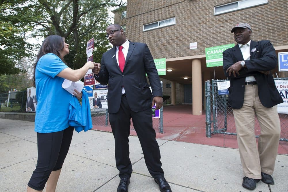 Boston City Councilor Tito Jackson fist bumps with a campaigner outside of the Holgate Apartments in Dorchester shortly after voting on Sept. 26. (Jesse Costa/WBUR)