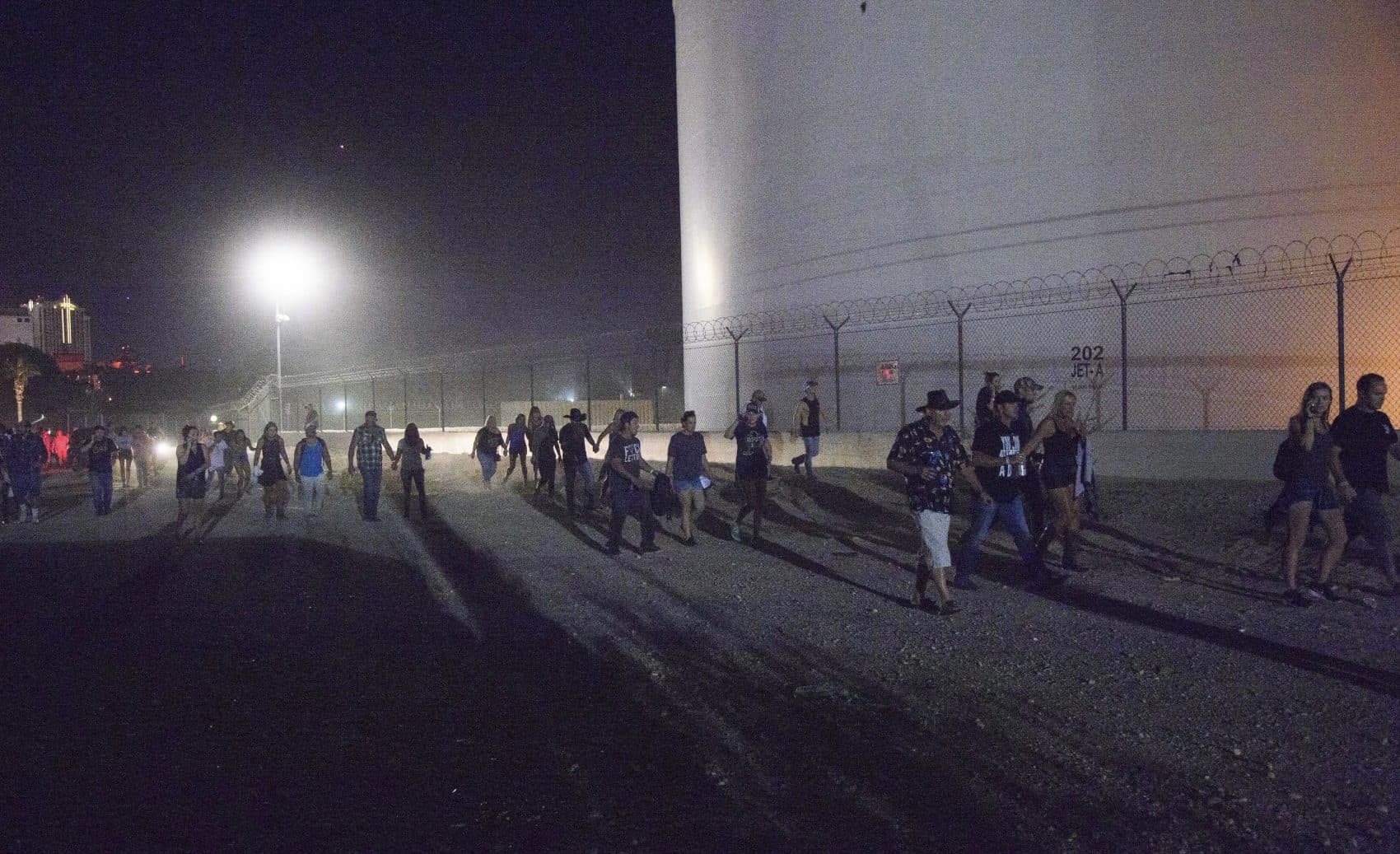 Concertgoers head for shelter outside of the Route 91 Harvest Festival after a gunman opened fire Sunday night. (Al Powers/Invsion/AP)