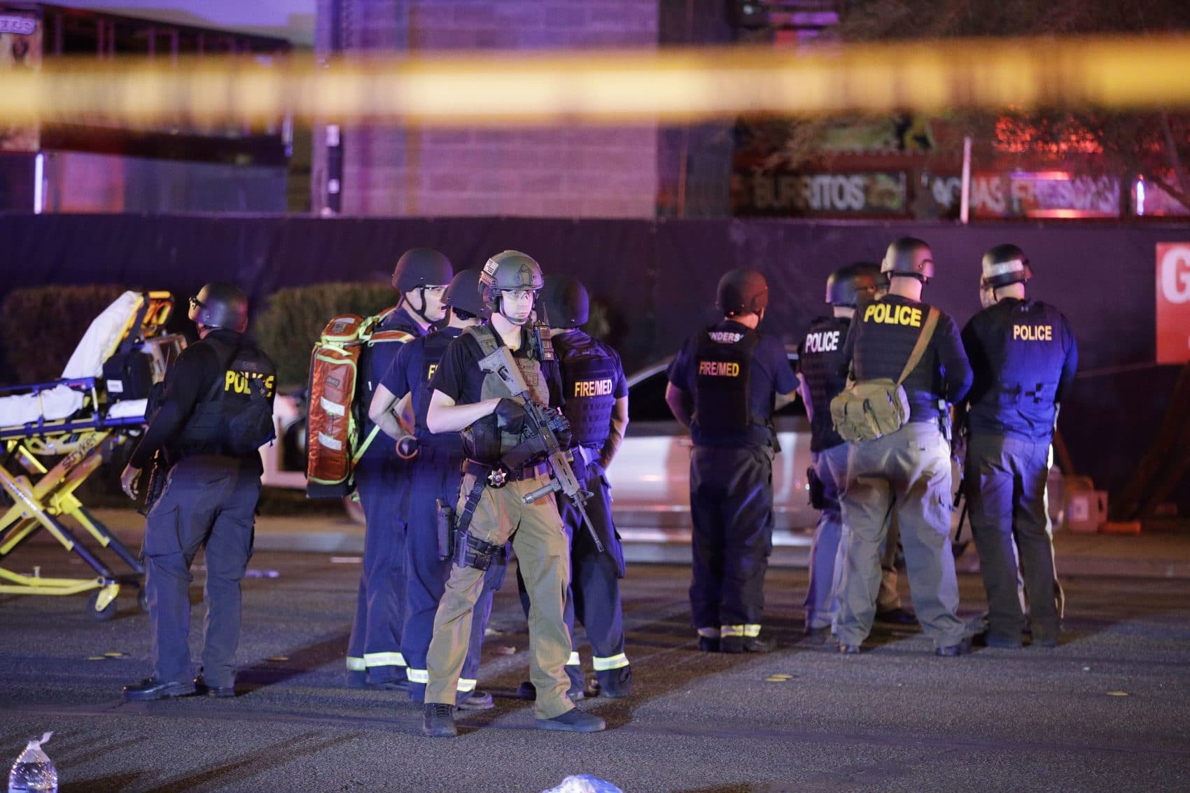 Police officers and medical personnel stand near the Mandalay Bay resort and casino on the Las Vegas Strip after a deadly shooting Sunday night at a music festival. (John Locher/AP)