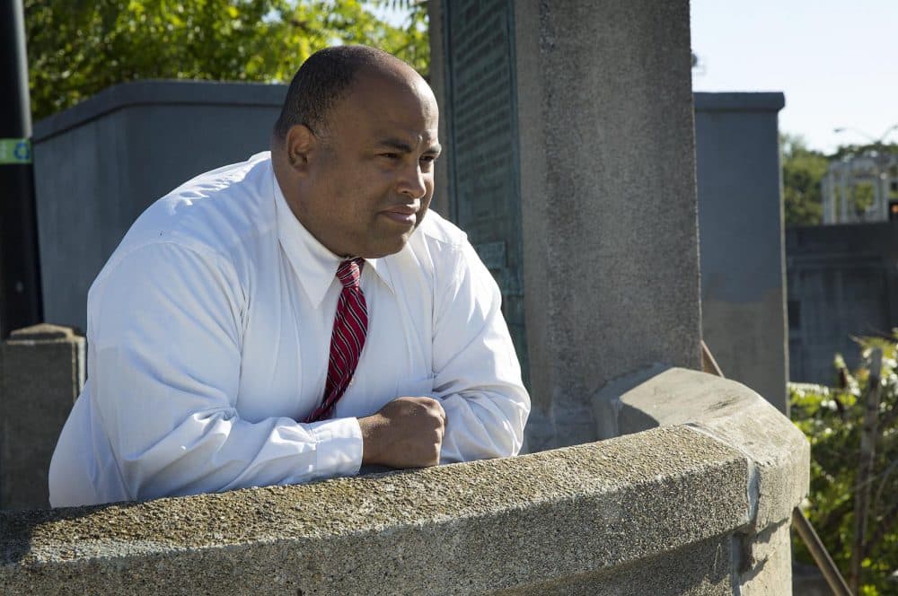 Lawrence Mayor Dan Rivera looks across the Merrimack River at an old stone dam. Rivera says the dam could potentially produce enough hydropower to create a self-sustaining renewable Amazon district powered by the canal and the dam. (Robin Lubbock/WBUR)