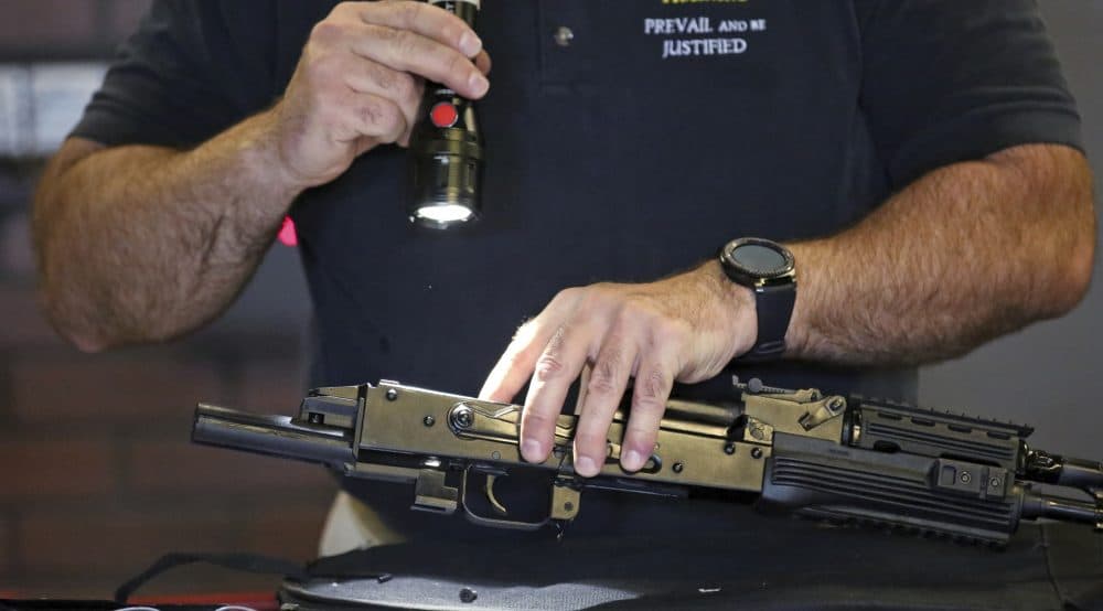 Clark Aposhian, chairman of the Utah Shooting Sports Council, demonstrates how a little-known device called a &quot;bump stock&quot; works when attached to a semi-automatic rifle at the Gun Vault store and shooting range in Utah. (Rick Bowmer/AP)