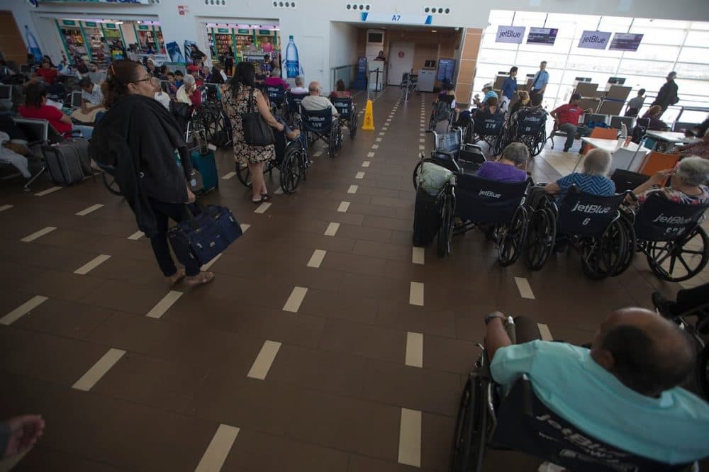 Airline travelers in wheelchairs wait to board the next flight out of Luis Muñoz Marin Airport in San Juan. (Jesse Costa/WBUR)