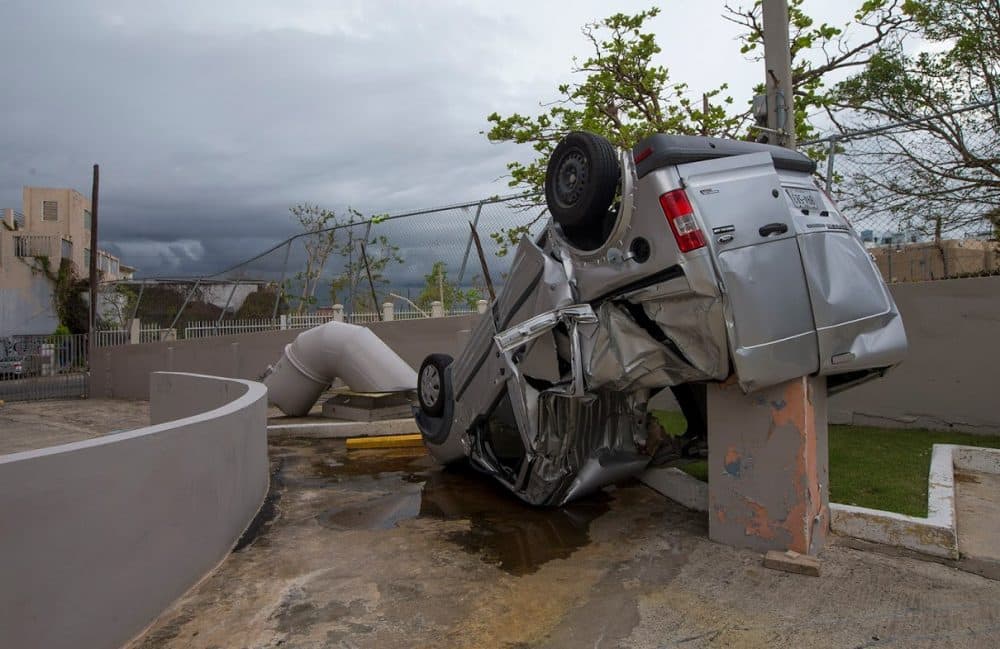A van was thrown and overturned during Hurricane Maria in a parking lot behind La Inmaculada Elderly Center in San Juan. (Jesse Costa/WBUR)