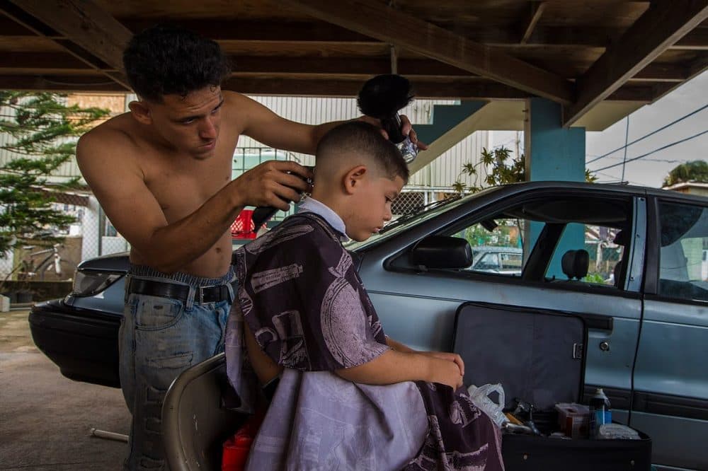 In the Juana Matos community in Cataño, Cristhian Llopiz gives haircuts to his neighbors in the area. (Jesse Costa/WBUR)