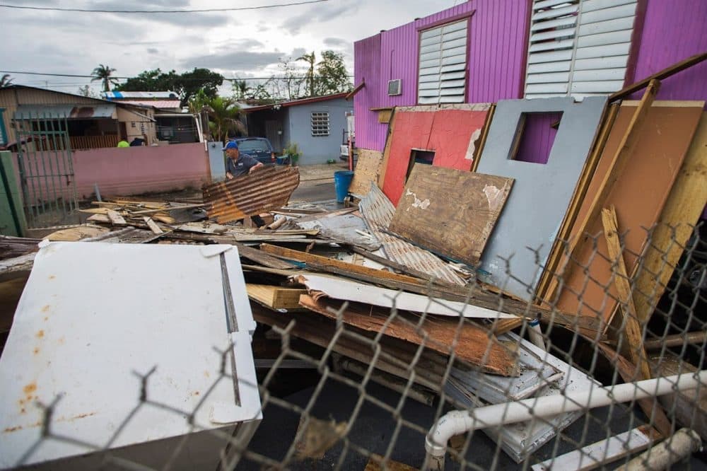 A man in Juana Matos, Cataño, rummages through the debris where his house once stood before Hurricane Maria hit the island. (Jesse Costa/WBUR)