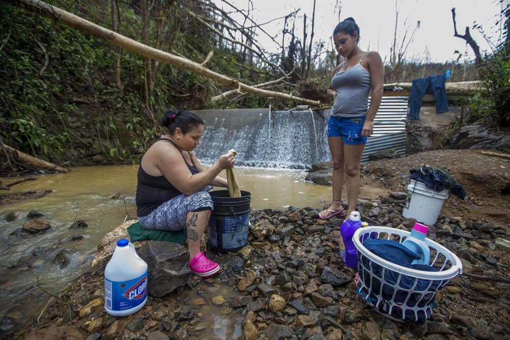 Jacquline Laporte Mammero and her daughter Darielys wash clothes in a stream in Cuchillas. (Jesse Costa/WBUR)