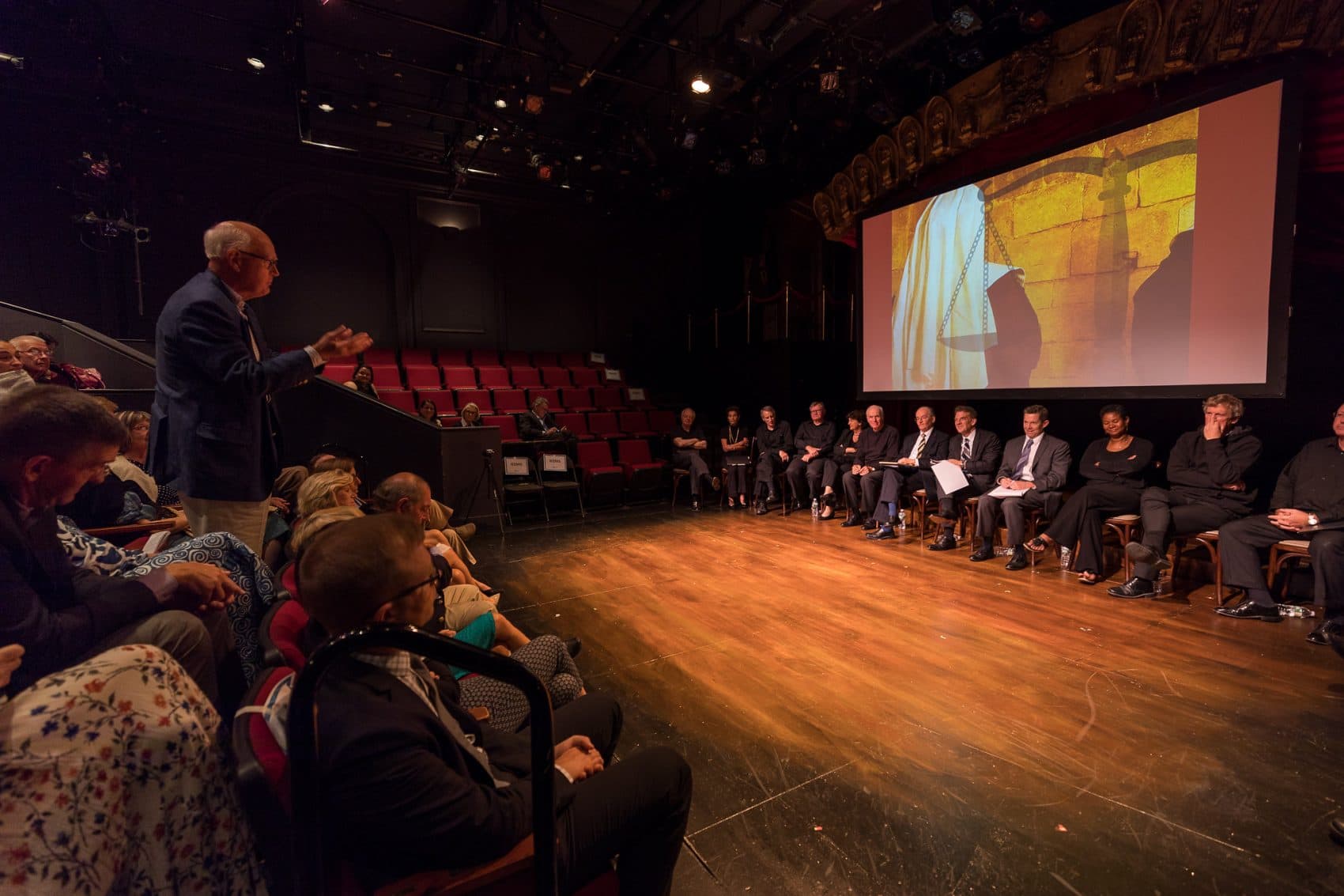 An audience member asks a question of the panel for "Shakespeare and the Law," staged by the Commonwealth Shakespeare Company. (Courtesy of Nile Hawer)