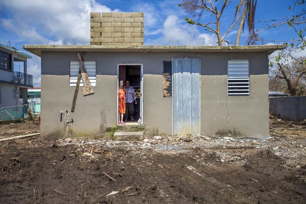 A man and a woman look outside their house in Punto Santiago, where Hurricane Maria first made landfall. (Jesse Costa/WBUR)