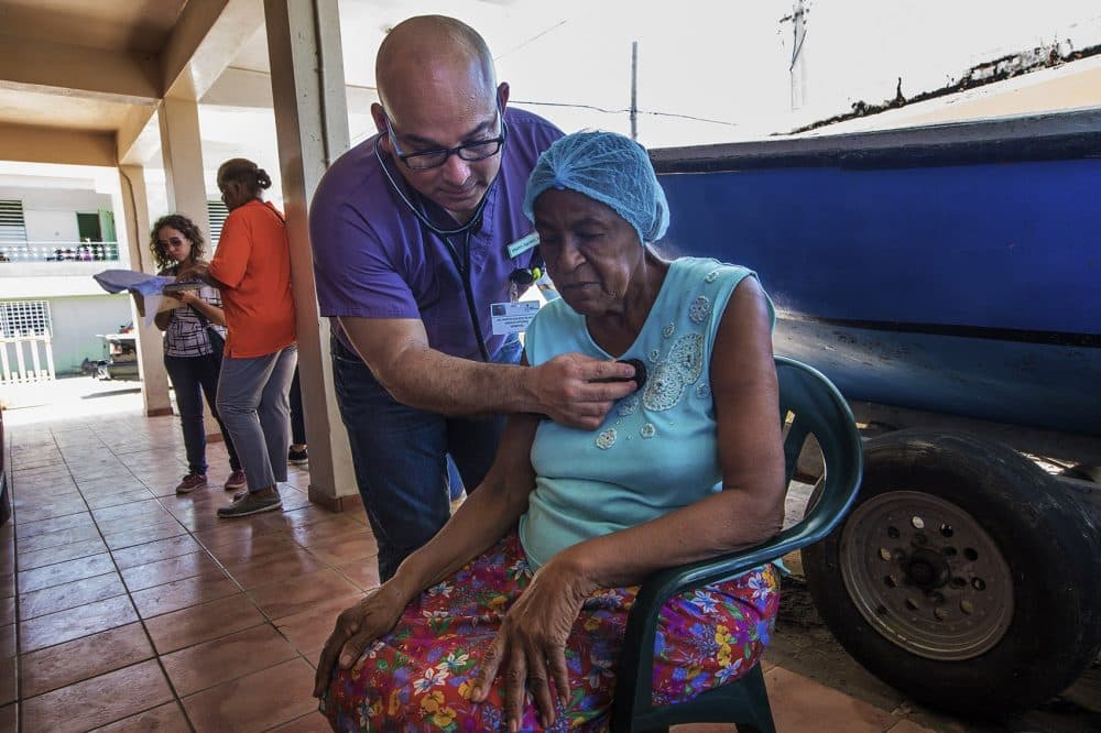 As part of the relief effort by El Programa de Educación Comunal de Entrega y Servicio (P.E.C.E.S.), a HIMAHEALTH volunteer Dr. Martin Agüero examines 74-year-old Arsenia Montañez Pizzarro at her home in Punta Santiago. (Jesse Costa/WBUR)