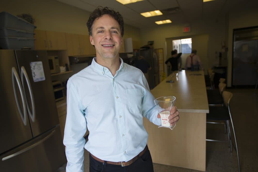 Josh Redstone holds his prototype of what he says is a new, more precise, measuring cup. (Jesse Costa/WBUR)