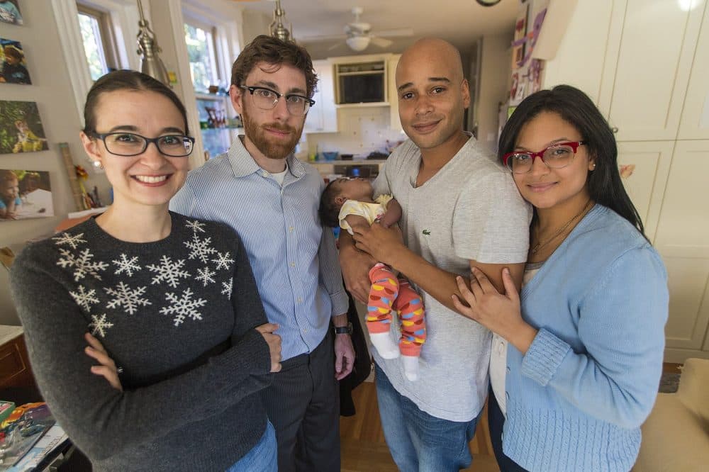 From left: Host family members Gwen Taylor and Jeff Lindy stand with Kelvin Garcia, holding Amaia, and Alianette Andino. (Jesse Costa/WBUR)