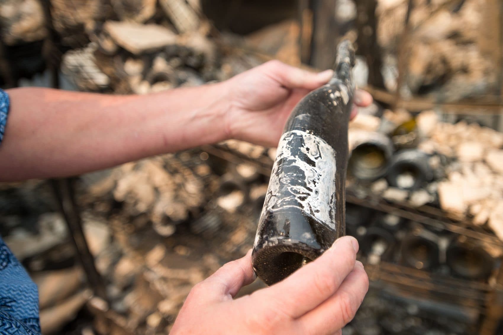 Winemaker Pierre Birebent inspects a melted wine bottle among the burned-out remains of the Signorello Estate Winery in Napa, Calif., on Oct. 11, 2017. (Josh Edelson/AFP/Getty Images)