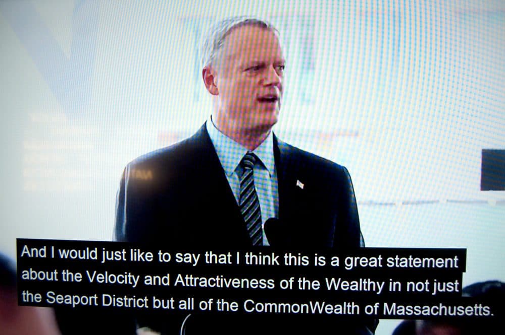 Massachusetts Gov. Charlie Baker appears to speak in a doctored video for the imagined groundbreaking of the &quot;Luxury Waters&quot; condo tower. (Greg Cook/WBUR)