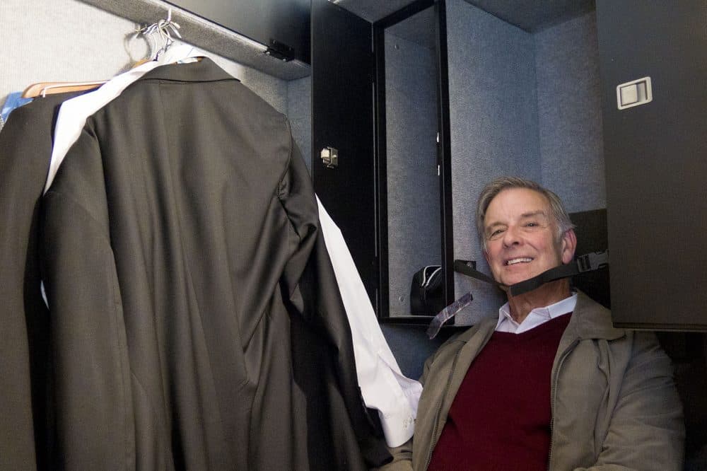 Assistant principal bassist Larry Wolfe climbs inside his gigantic travel case and jokes that it's the size of a coffin. (Andrea Shea/WBUR)