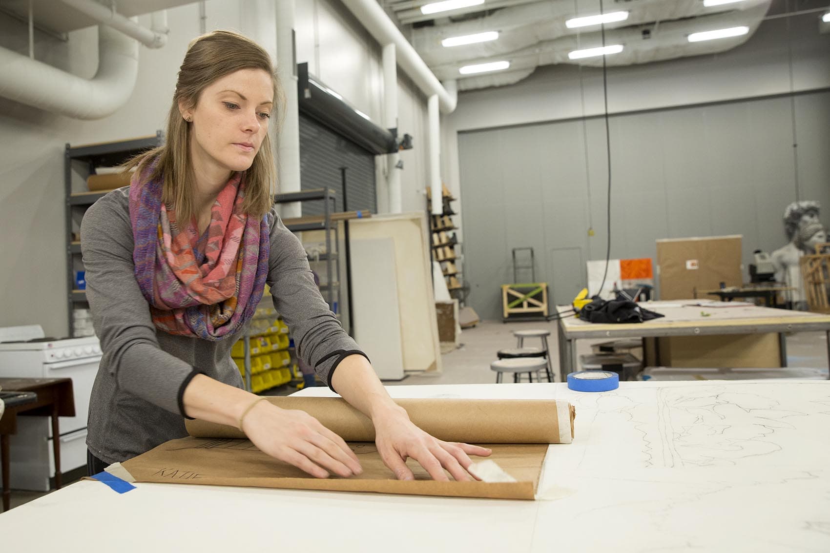 Graduate student Katherine Keaton works on a fabric study at BU's new theater production center. (Robin Lubbock/WBUR)