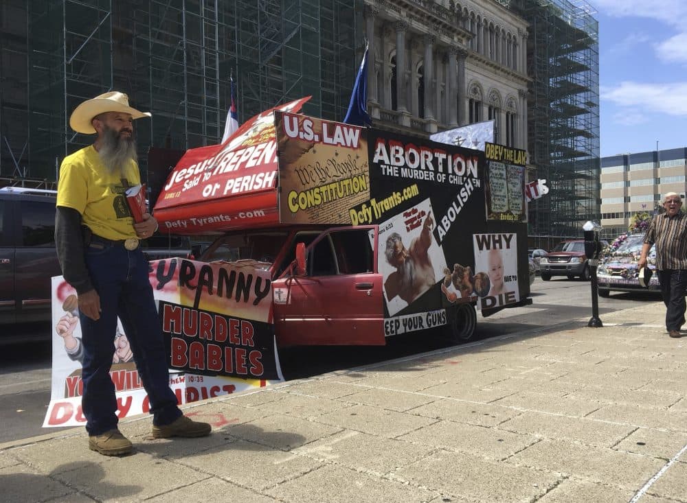 In this July 19, 2017, photo, an abortion opponent stands beside signs during a rally in downtown Louisville, Ky. The protesters are with a group called Operation Save America that is planning a weeklong event at Kentucky's last abortion clinic with the hopes that it will shut down. (Dylan Lovan/AP)