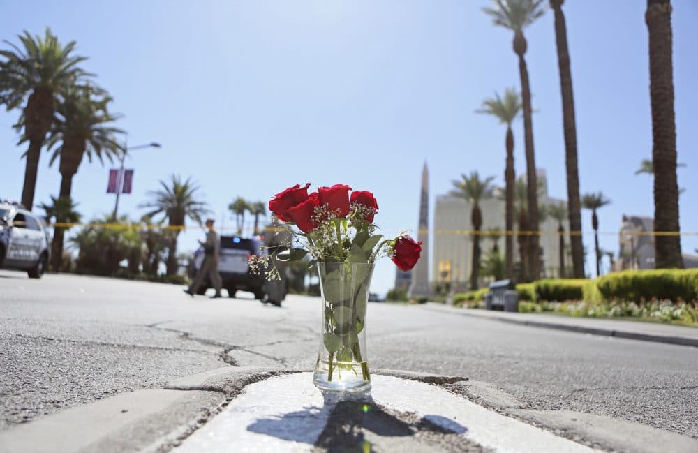A vase of roses is shown at the edge of a police barricade on the Las Vegas Strip Monday, Oct. 2, 2017, in Las Vegas. A mass shooting occurred late night Sunday at a music festival on the Las Vegas Strip. (Ronda Churchill/AP)