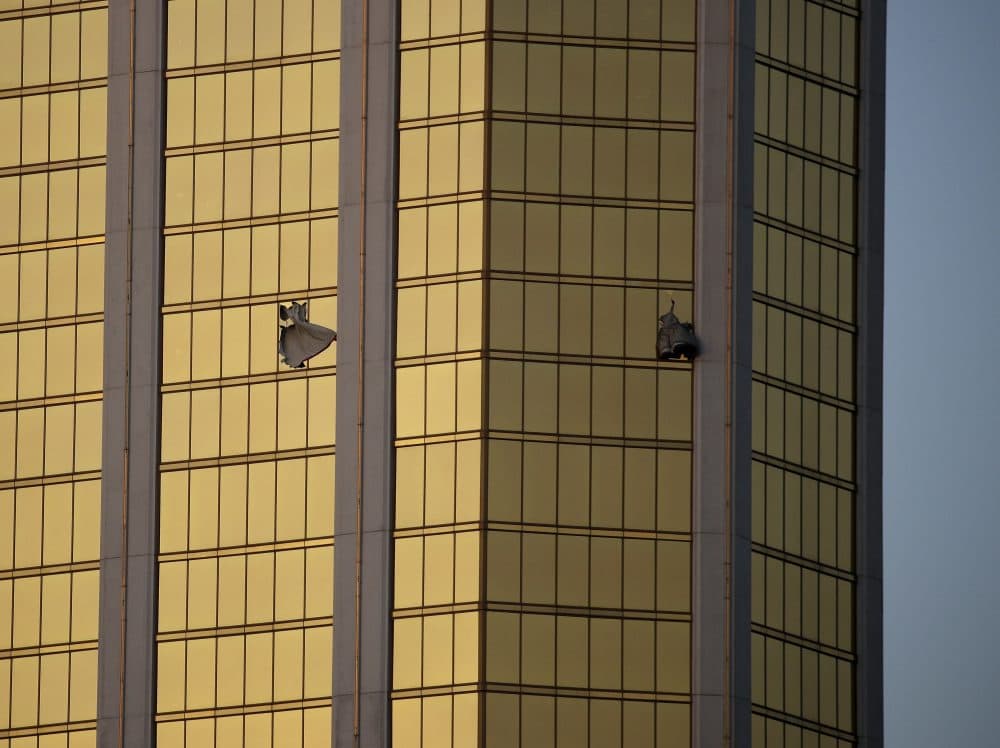 In this Oct. 2 file photo, drapes billow out of broken windows at the Mandalay Bay resort and casino on the Las Vegas Strip, following a mass shooting at a music festival. (John Locher/AP)