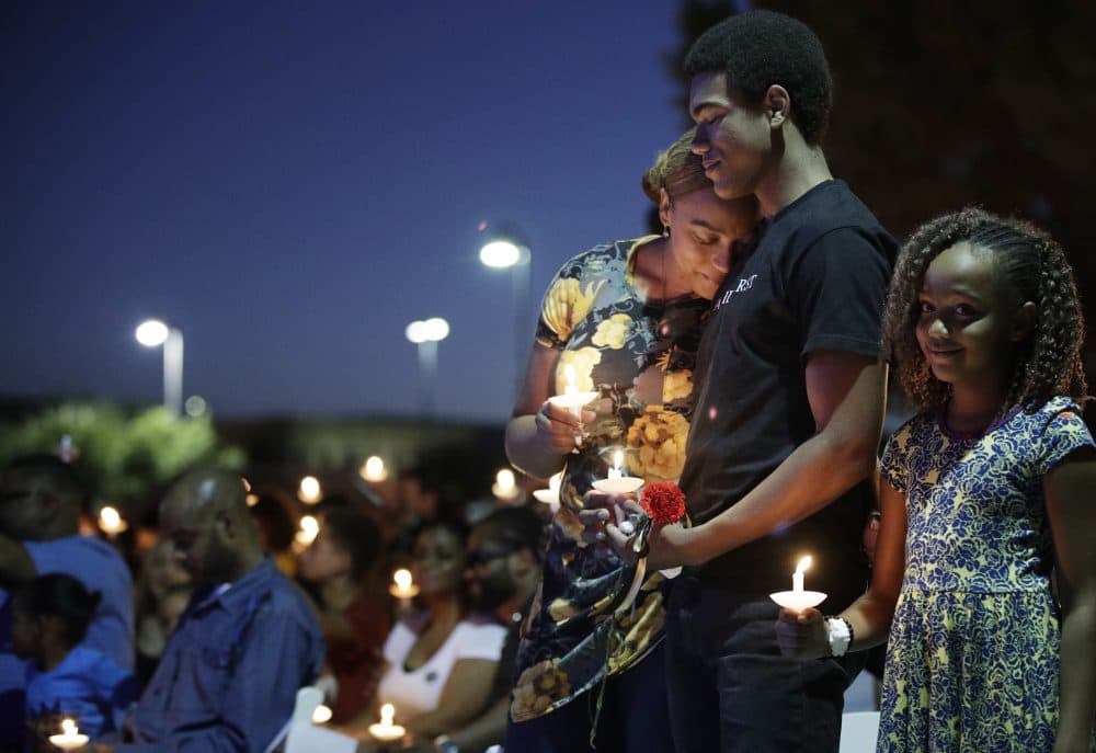 From left, Veronica Hartfield, wife of Las Vegas police officer Charleston Hartfield, embraces son Ayzayah Hartfield beside daughter Savannah Hartfield during a candlelight memorial for the officer, Thursday, Oct. 5, 2017, in Las Vegas. Hartfield was killed when Stephen Craig Paddock broke windows on the Mandalay Bay resort and casino and began firing with a cache of weapons at a country music festival Sunday. Dozens of people were killed and hundred were injured. (John Locher/AP)