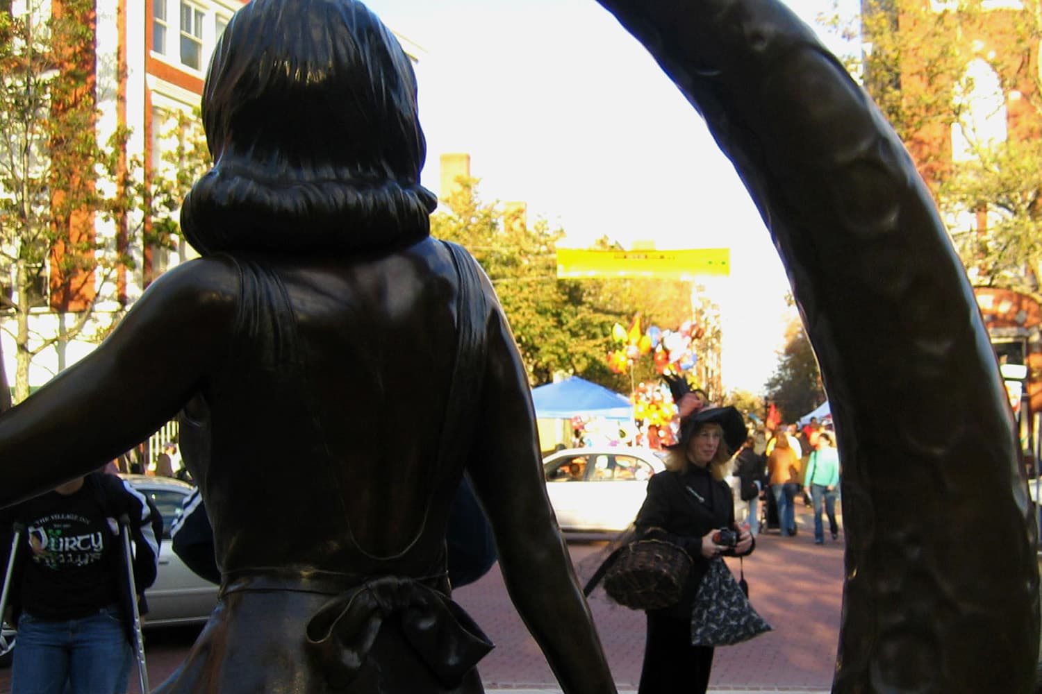 A woman dressed as a witch is framed by a statue in downtown Salem of Samantha Stevens, the witch on the TV show "Bewitched."