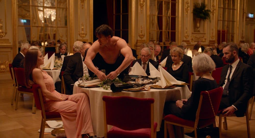 Terry Notary (pictured on the table) plays a performance artist in &quot;The Square.&quot; (Courtesy Magnolia Pictures)
