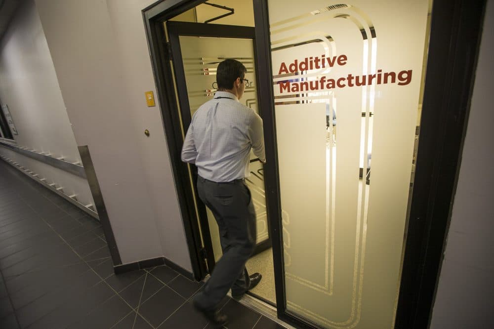 Chris DiBiasio, group leader for advanced manufacturing, walks into the Additive Manufacturing facility at Draper Labs. (Jesse Costa/WBUR)