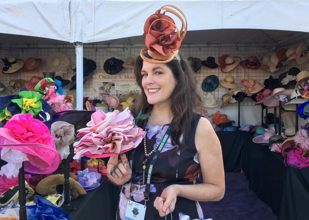 Christine Moore, owner of Christine A. Moore Millinery, selling hats at the track. (Alex Ashlock/Here &amp; Now)