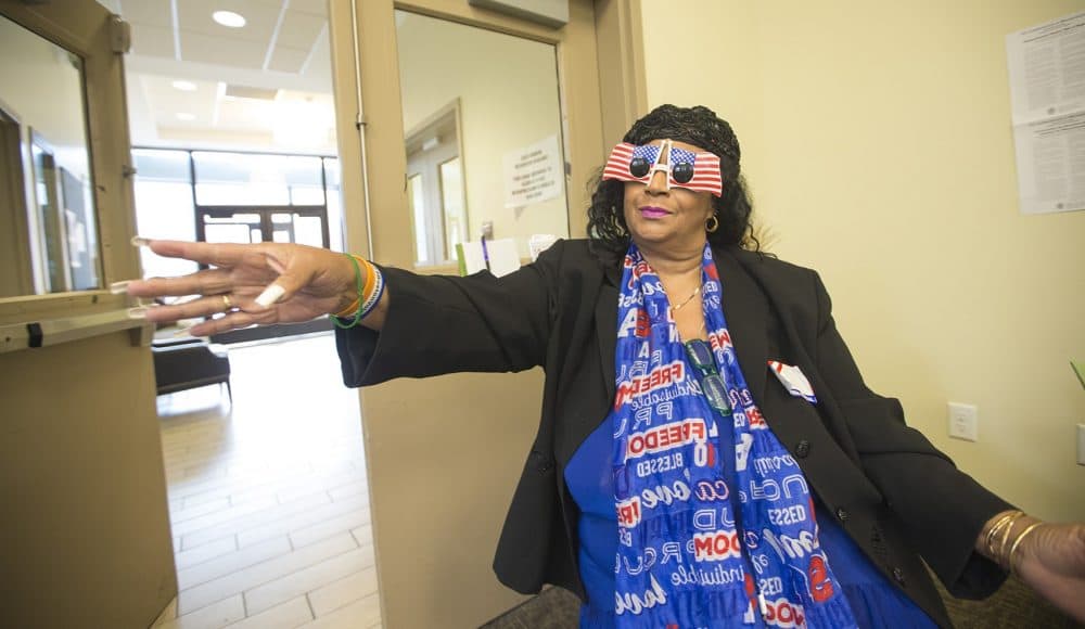 Volunteer Eileen Kenner of Uphams Corner was sporting some pretty patriotic glasses as she guided voters to where they needed to go at the Uphams Crossing residential building. (Jesse Costa/WBUR)