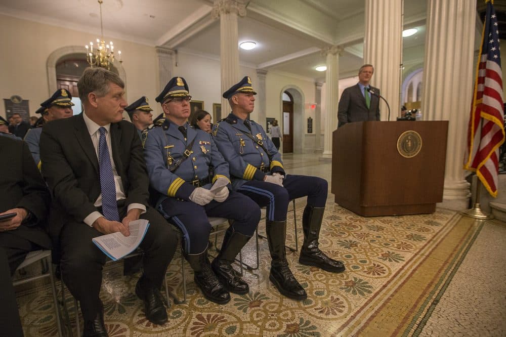 From left: State Public Safety Secretary Daniel Bennett, Lieutenant Colonel Francis Hughes and Colonel Richard McKeon listen while Gov. Charlie Baker speaks during the Massachusetts State Police Fall Awards Ceremony at the State House. (Jesse Costa/WBUR)