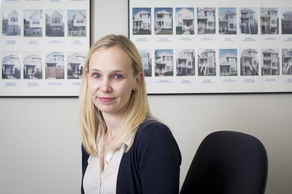 Kristen Komara, vice president of financial wellness at the Resurrection Project, pictured at the Resurrection Project in Pilsen on Nov. 6, 2017, in Chicago. The houses pictured behind are of the first 140 homes built by the organization in the '90s that it then helped community members purchase. (Michelle Kanaar for Here &amp; Now)