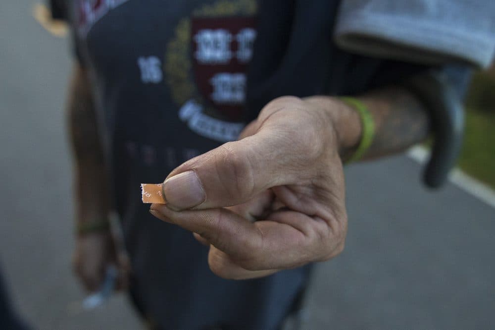 Joe pulls out a tab of Suboxone. (Jesse Costa/WBUR)