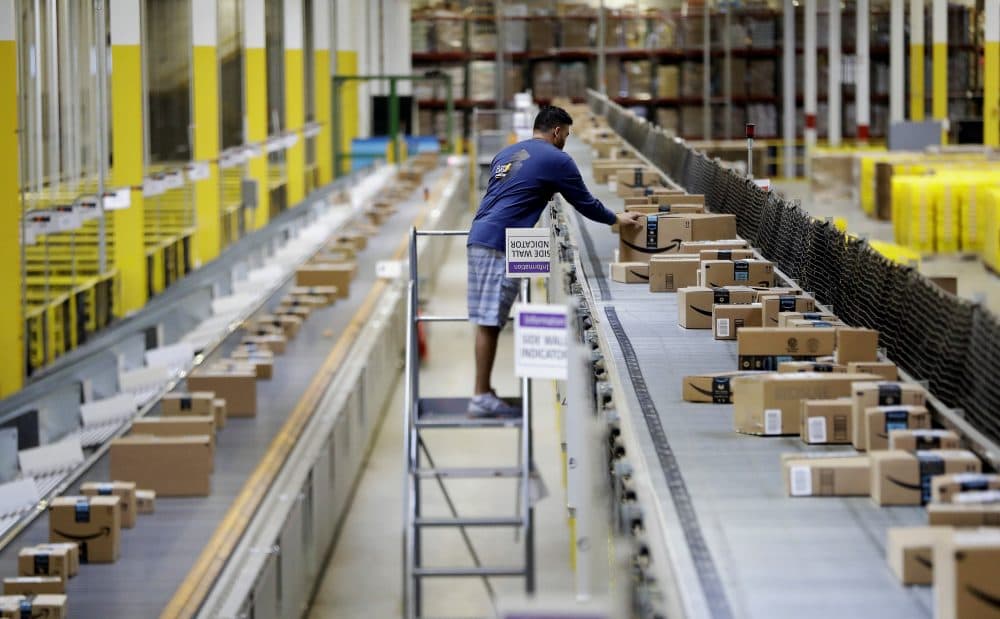 In this Tuesday, Aug. 1, 2017, photo, an Amazon employee makes sure a box riding on a belt is not sticking out at the Amazon Fulfillment center in Robbinsville Township, N.J. (Julio Cortez/AP)