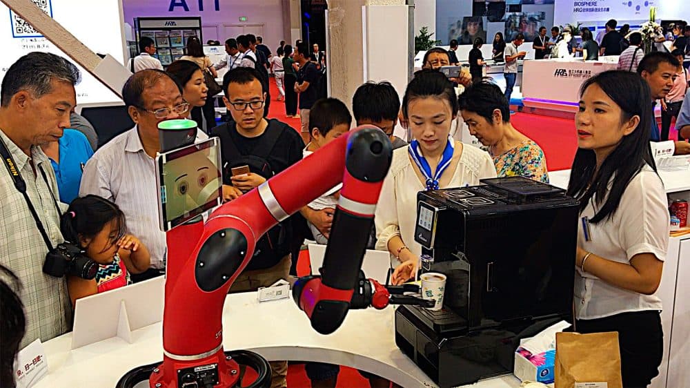 Sawyer, a Rethink robotic arm, makes coffee for visitors at the World Robot Conference in Beijing. Rethink Robotics began selling the robots in China in the summer of 2016. (Asma Khalid/WBUR)