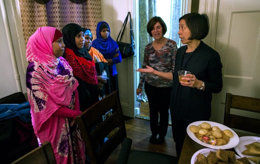 From left: Muna, Hawo, their mother Fatuma Nur and Asha listen as Sherry Mulroy, far right, explains the history of Thanksgiving. (Jesse Costa/WBUR)