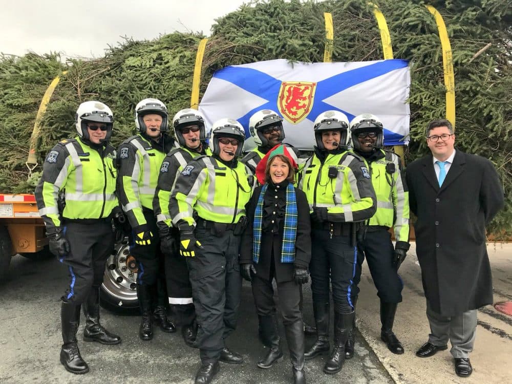 Nova Scotia Deputy Premier Karen Casey, Boston Parks Comissioner Christopher Cook and Halifax Regional Police pose for a picture with the tree as it's bundled up to head to Boston. (Courtesy @TreeForBoston)