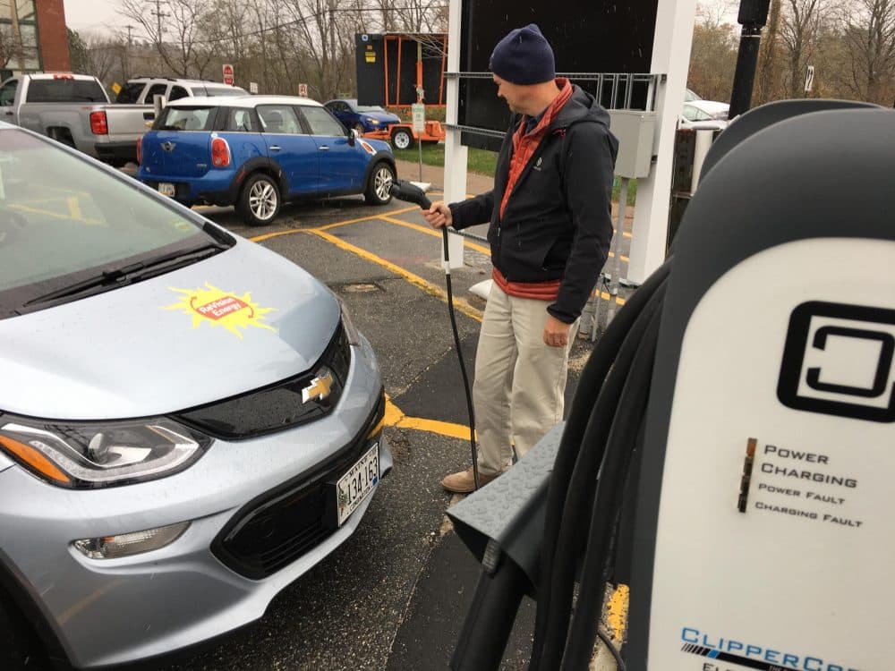 ReVision Energy's Barry Woods charges up his company car in Brunswick. (Fred Bever/Maine Public Radio)