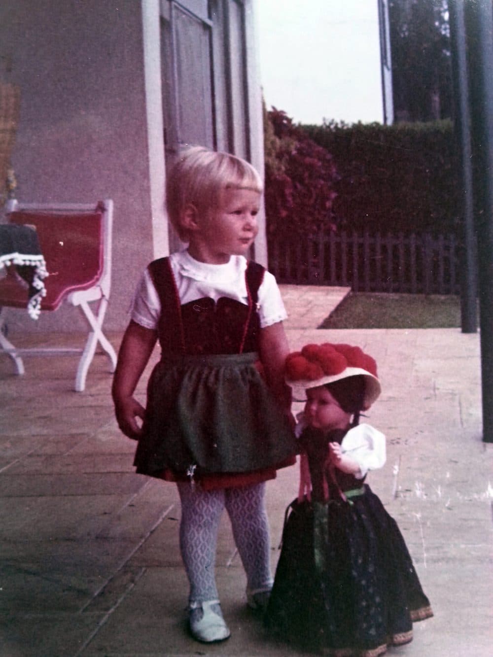 Julie, aged 3, in Brazil, dragging along a Bavarian doll and dressed in the dirndl, a traditional German dress, which she wore when her grandparents came to visit. (Courtesy of Julie Lindahl)