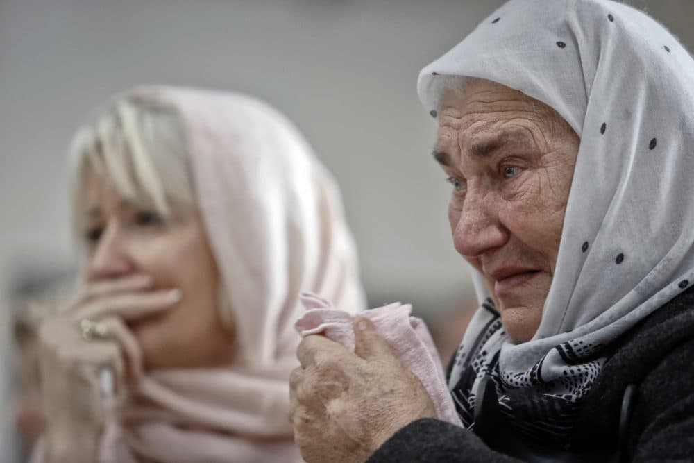 Bosnian women are overwhelmed by emotion watching the final moments of Mladić's trial at the memorial center in Potocari, near Srebrenica, Bosnia, Wednesday, Nov. 22, 2017. (Amel Emric/AP)